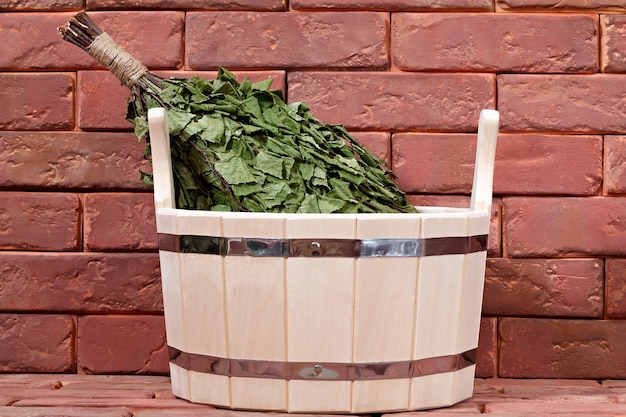 Seau pour un bain sur une surface en brique. Équipement pour sauna