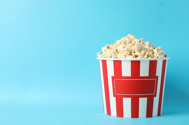 Seau à rayures avec pop-corn sur fond bleu