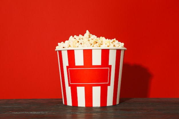 Seau à rayures avec pop-corn sur fond rouge