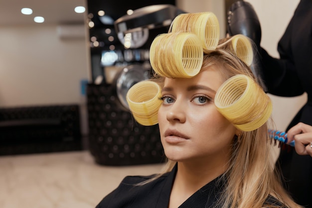 Séchage des cheveux blonds avec sèche-cheveux et brosse ronde