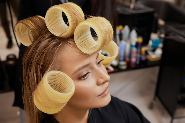 Séchage des cheveux blonds avec sèche-cheveux et brosse ronde.