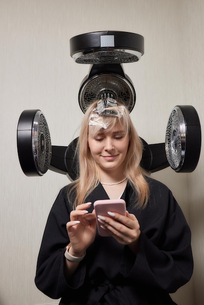 Séchage des cheveux blonds avec sèche-cheveux et brosse ronde