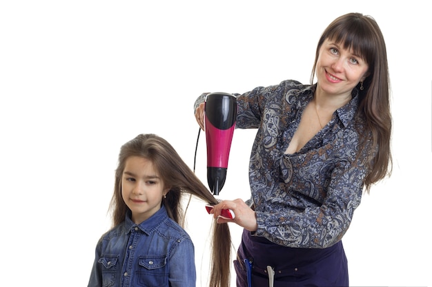 Sèche-cheveux maman de ses petites filles isolé sur fond blanc