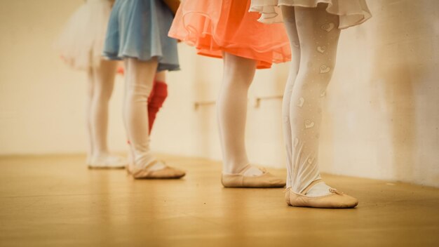 Photo section basse des danseurs de ballet debout sur le sol en bois dur