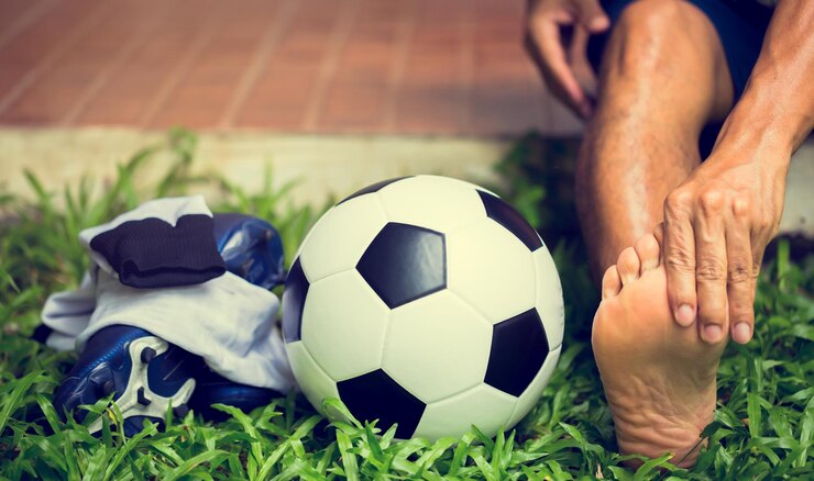 Photo section basse d'un homme jouant au football sur l'herbe