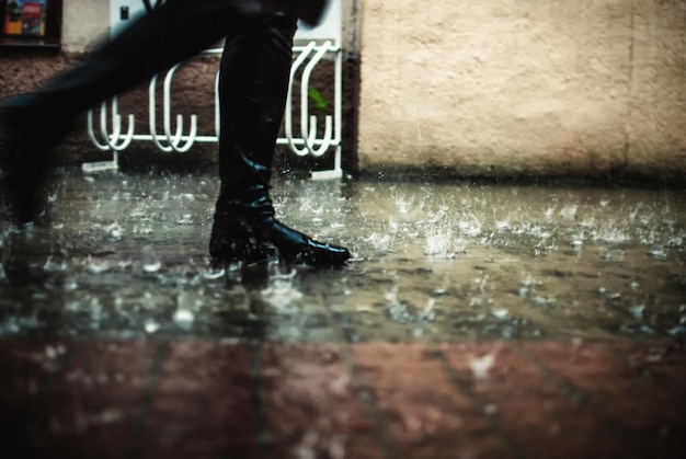 Section basse d'une personne marchant sur un sentier pendant la pluie