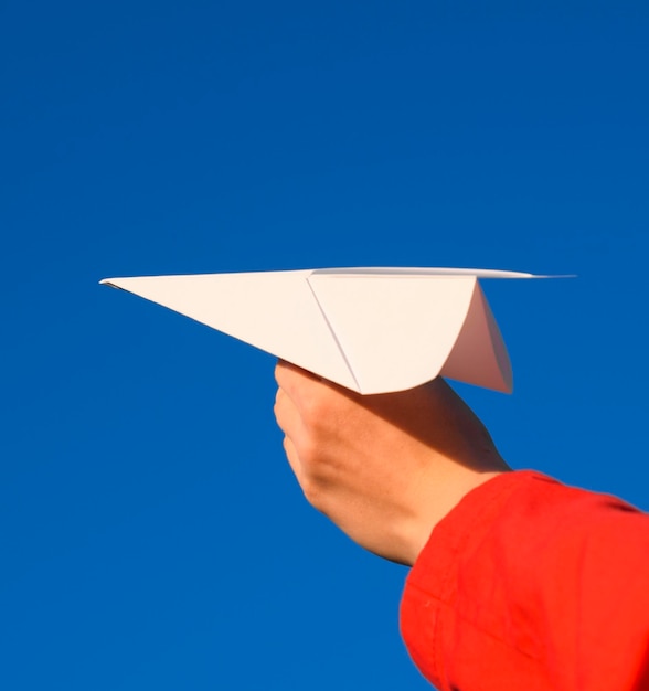 Section basse d'une personne tenant un parapluie contre un ciel bleu clair