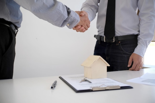 La section centrale de l'agent immobilier serrant la main d'un client au bureau