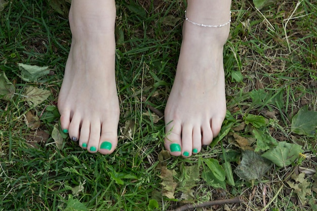 Section inférieure d'une femme avec des ongles peints sur le terrain