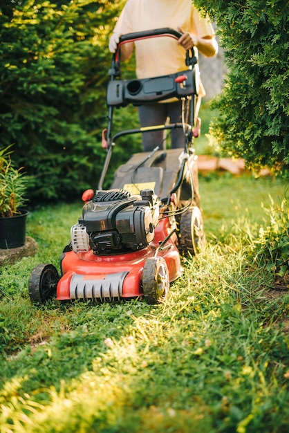 Section inférieure d'une femme utilisant une tondeuse à gazon