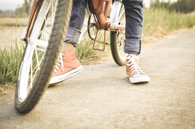 Section inférieure d'un homme debout avec un vélo