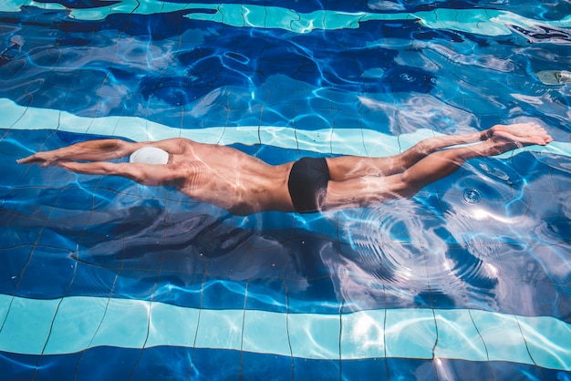 Section inférieure d'un homme nageant dans une piscine