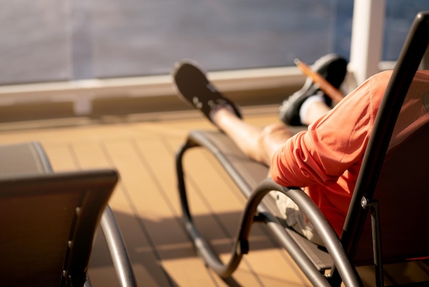 Photo section inférieure de l'homme se détendant sur une chaise