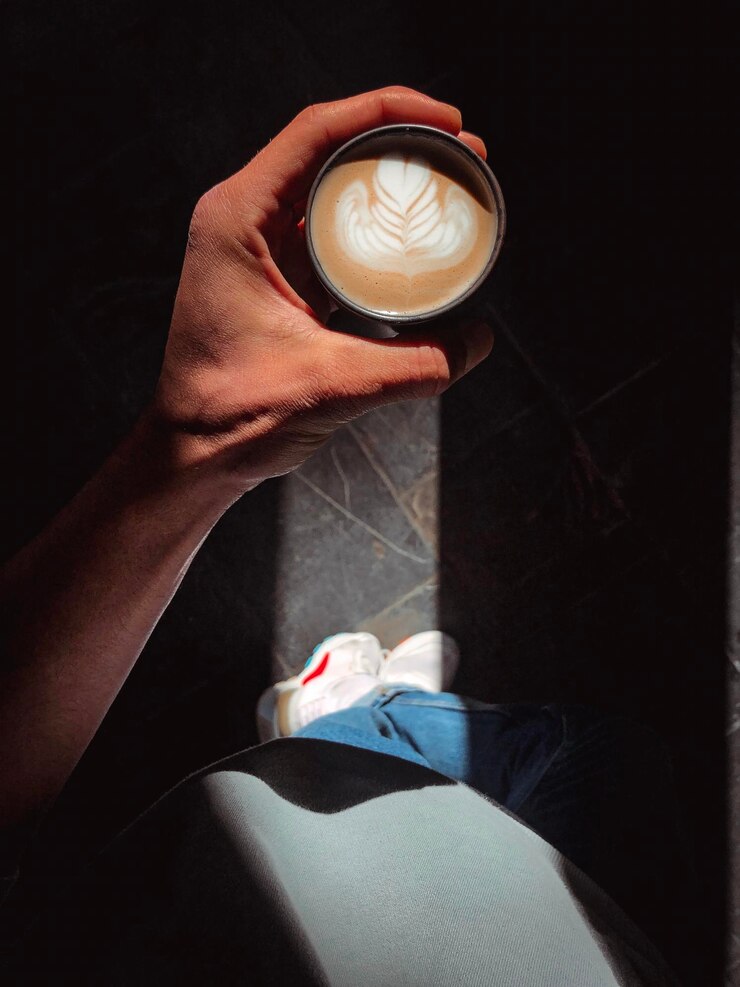 Photo section inférieure de l'homme tenant une tasse de café