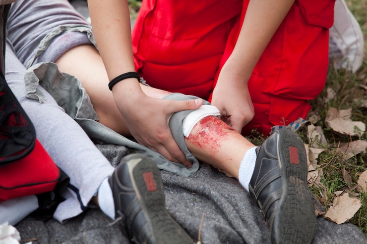 Photo section inférieure de l'infirmière assise à côté d'une femme blessée sur le terrain