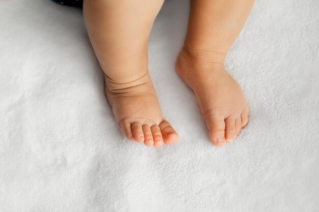 Photo section inférieure des pieds du bébé sur le lit