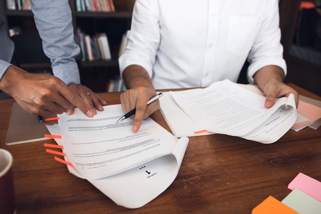 Une section intermédiaire d'étudiants discutant des articles sur la table de la bibliothèque