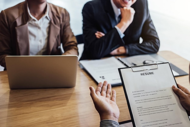 Une section intermédiaire de gestionnaires en train d'interviewer sur une table dans le bureau