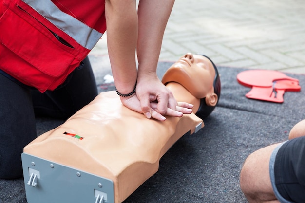 Photo section médiane des ambulanciers pratiquant sur le mannequin de réanimation cardiaque à la couverture