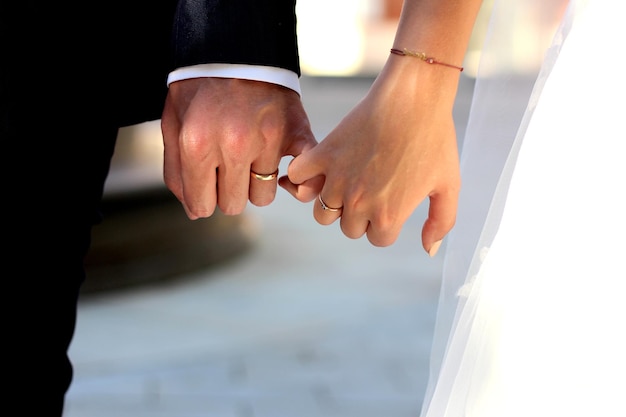 Section médiane d'un couple de jeunes mariés se tenant par la main