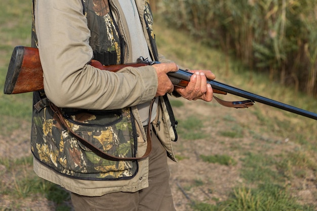 La section médiane du chasseur d'hommes se tient avec une arme à feu dans ses mains