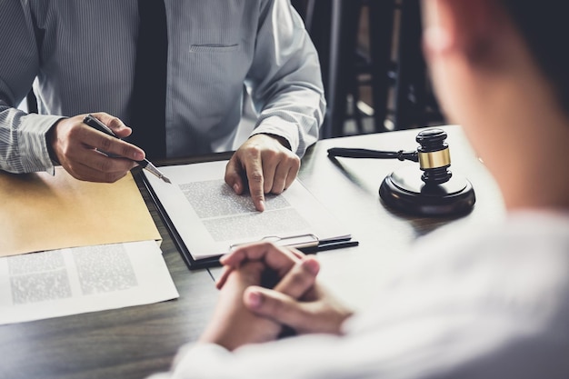 La section médiane du juge pointant vers le document pendant que le client inquiet est assis sur la table