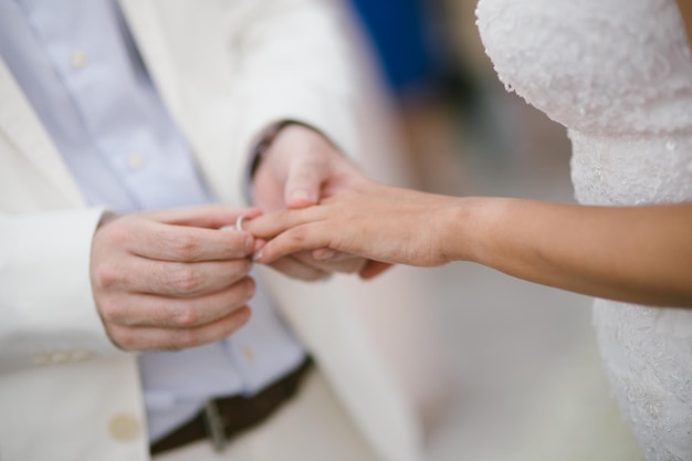 La section médiane de l'époux mettant l'anneau de mariage dans le doigt de la mariée