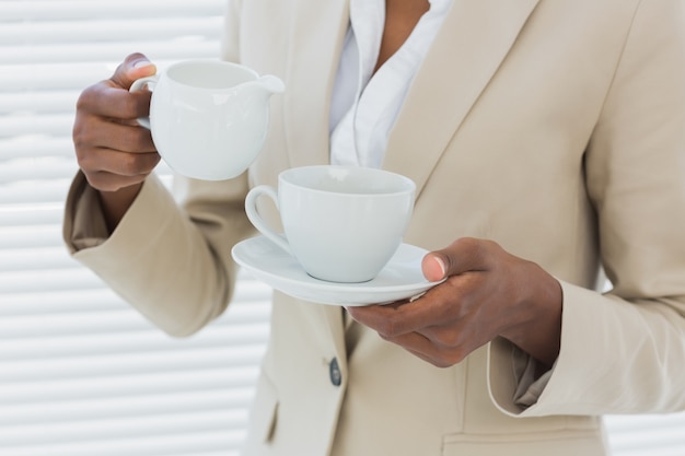 Section médiane de femme d&#39;affaires élégant avec une tasse de thé