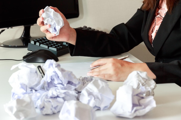 Photo section médiane d'une femme d'affaires tenant un papier froissé au bureau