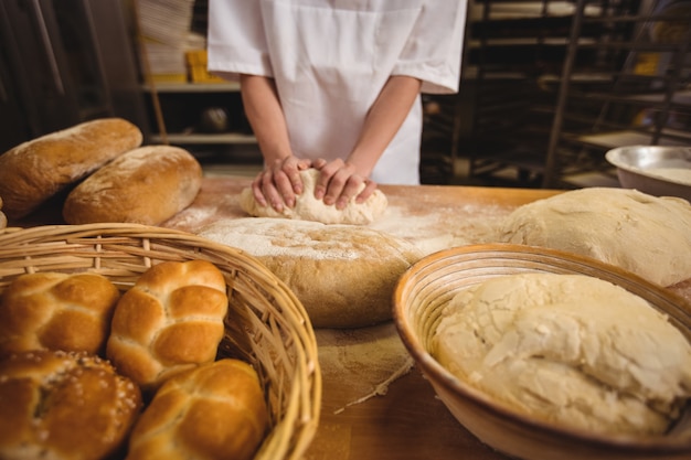 Section médiane d'une femme boulangère pétrir une pâte