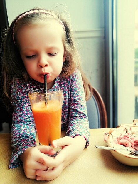 Photo section médiane d'une femme buvant un verre avec une boisson sur la table