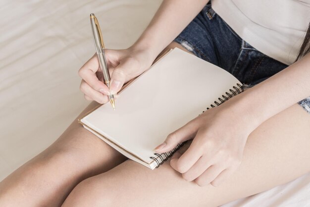 Photo section médiane d'une femme écrivant dans un livre