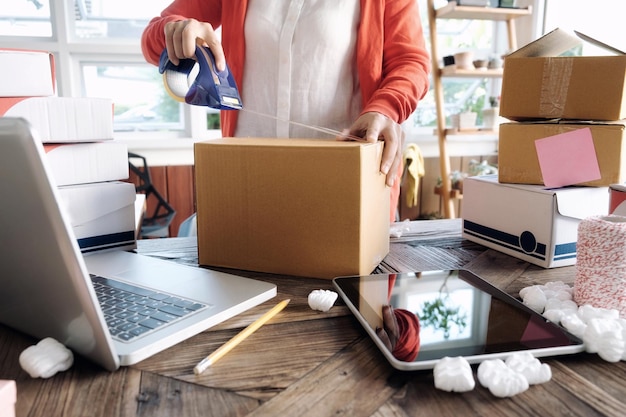 Section médiane d'une femme emballant une boîte en carton au bureau
