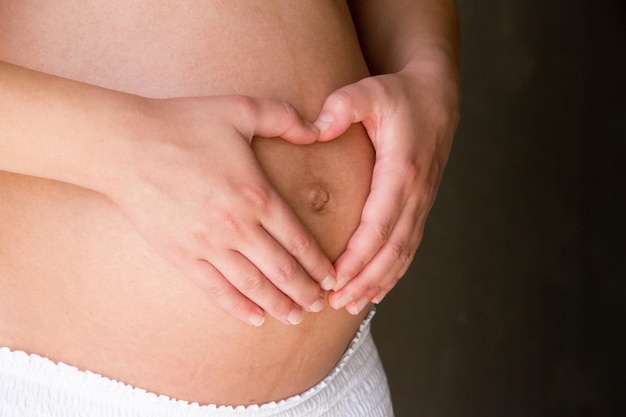 Section médiane d'une femme enceinte en forme de cœur sur le ventre