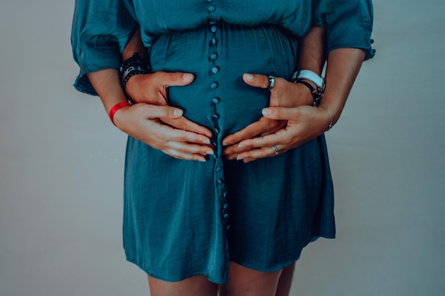 Section médiane d'une femme enceinte avec un homme debout sur un fond bleu