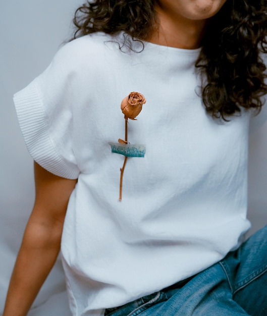 Photo section médiane d'une femme avec une fleur de rose sur une robe blanche