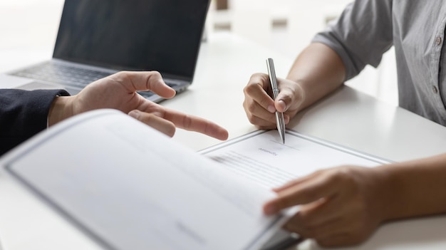 Section médiane d'une femme lisant un livre assise sur une table