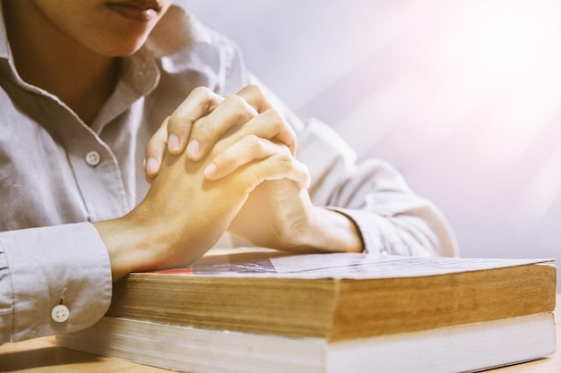 Photo section médiane d'une femme avec les mains serrées sur un livre