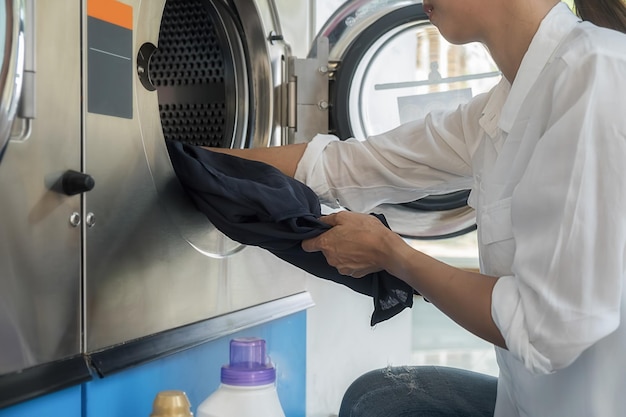Section médiane d'une femme mettant du linge dans la machine à laver