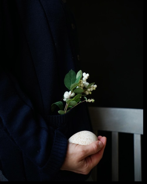 Section médiane d'une femme tenant des fleurs et un œuf