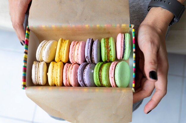 Photo section médiane d'une femme tenant des macaroons dans une boîte