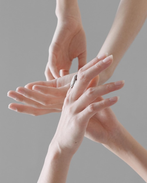 Section médiane d'une femme tenant les mains sur un fond blanc