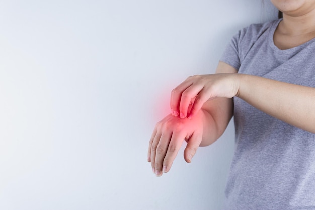 Section médiane d'une femme tenant les mains sur un fond blanc