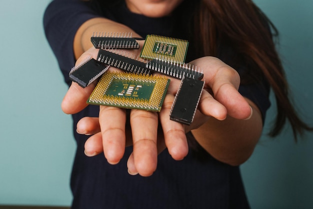 Section médiane d'une femme tenant des pièces de téléphone portable et des micropuces