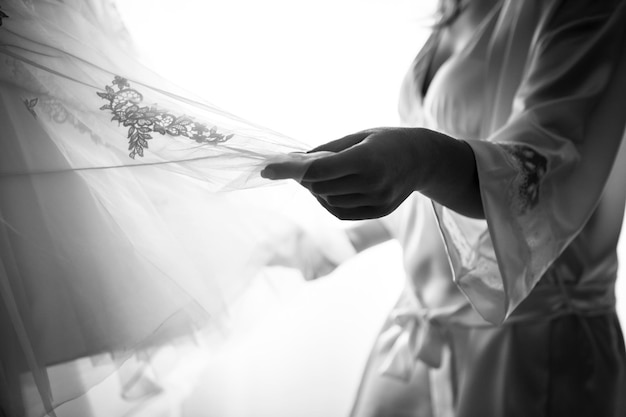 Photo section médiane d'une femme tenant une robe de mariée à la maison