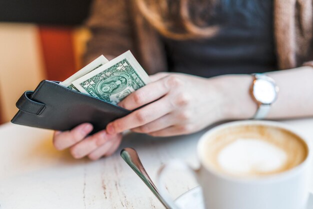 Section médiane d'une femme tenant une tasse de café sur la table