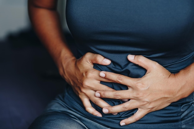 Photo section médiane de la femme touchant l'abdomen dans la douleur