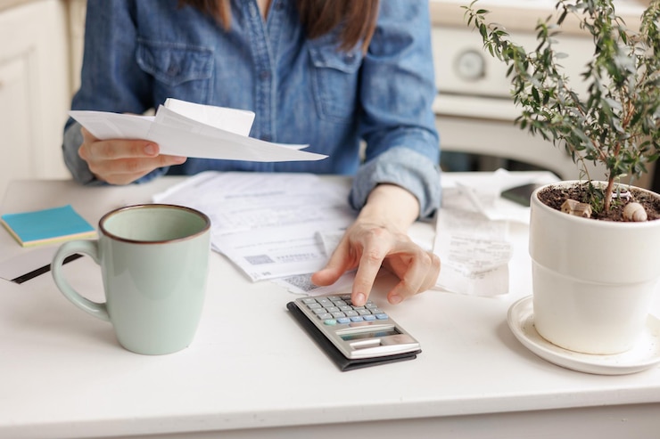 Photo section médiane d'une femme utilisant une calculatrice au bureau
