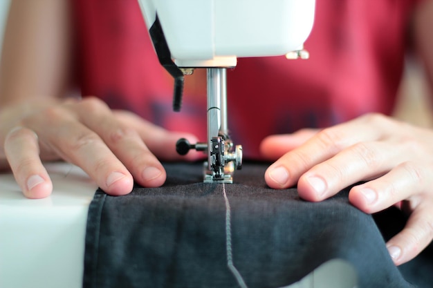 Section médiane d'une femme utilisant une machine à coudre