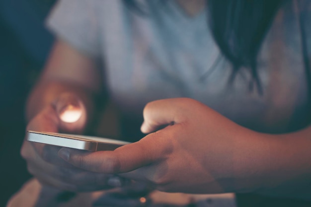 Section médiane d'une femme utilisant un téléphone dans la chambre noire